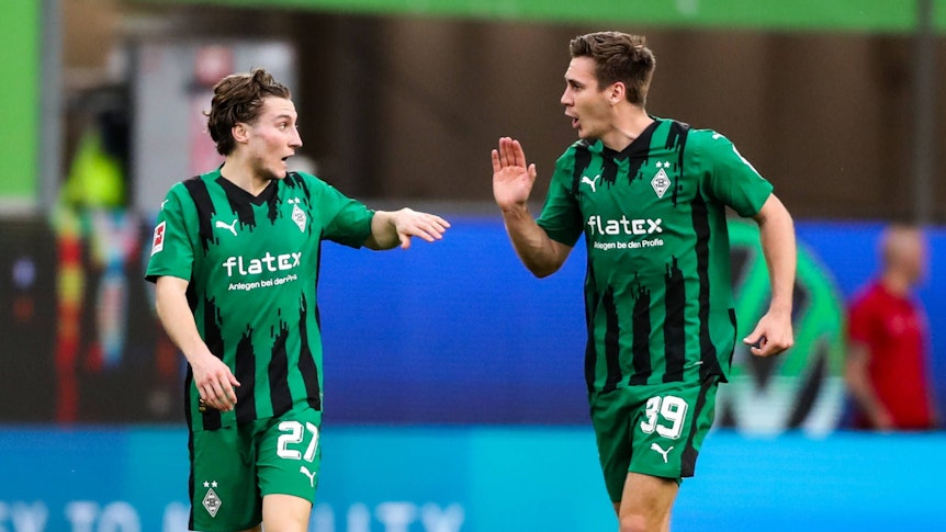 Die Gladbach-Profis Rocco Reitz und Maximilian Wöber klatschen sich im Bundesliga-Spiel beim VfL Wolfsburg ab.
