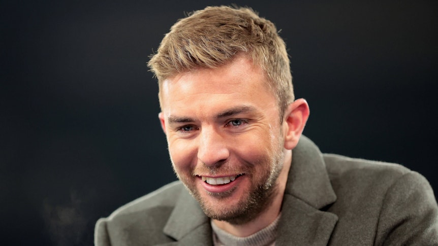 Experte Christoph Kramer steht beim Champions-League-Spiel Schachtar Donezk gegen den FC Bayern München lachend am Moderatorenpult.