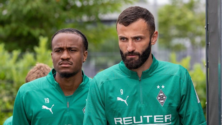 Die Gladbach-Profis Franck Honorat und Nathan Ngoumou laufen hintereinander auf den Trainingsplatz.