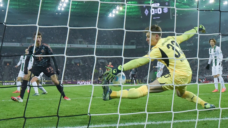 Borussia Mönchengladbachs Keeper Moritz Nicolas pariert einen Schuss von Bayern Münchens Thomas Müller mit der linken Hand.
