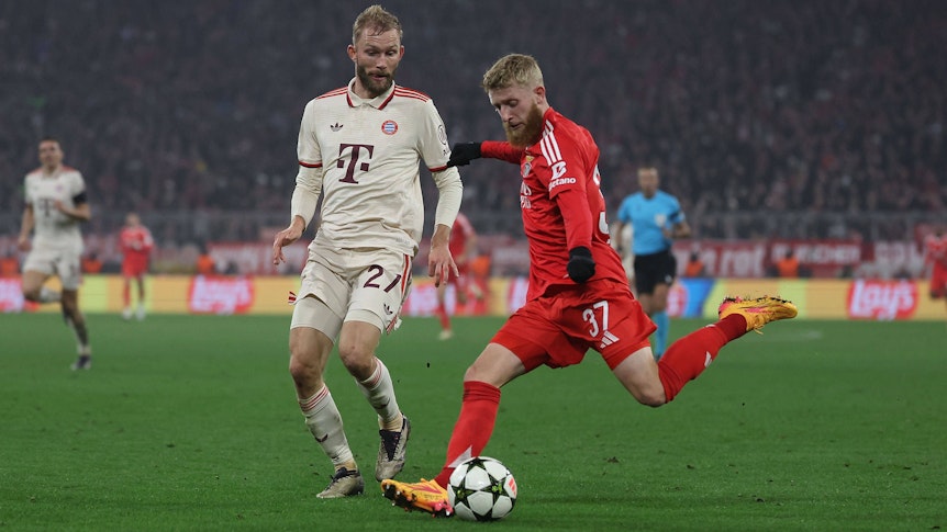 Jan-Niklas Beste schlägt im Benfica-Trikot eine Flanke. Konrad Laimer vom FC Bayern München kann nur zuschauen.