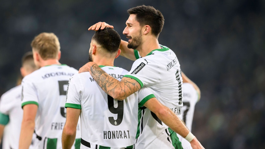Die Gladbach-Profis Tim Kleindienst und Franck Honorat stehen im Bundesliga-Spiel gegen Werder Bremen Arm in Arm auf dem Platz.