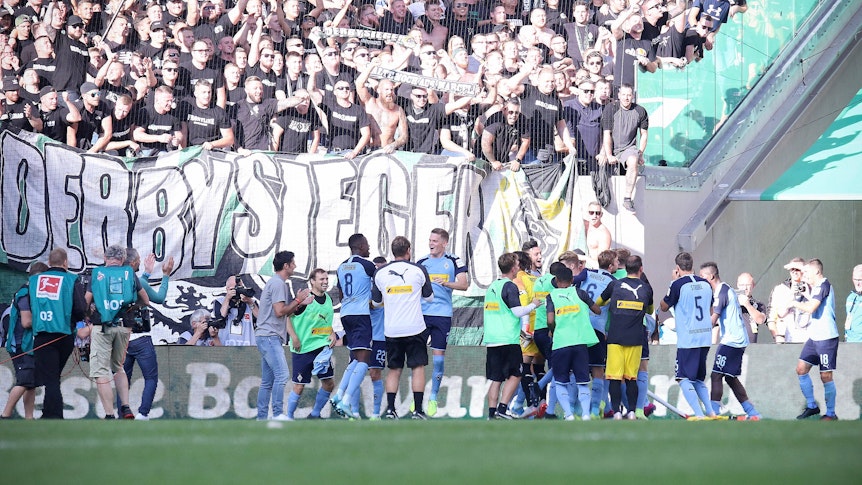 Spieler von Borussia Mönchengladbach feiern einen Derbysieg mit den Fans.
