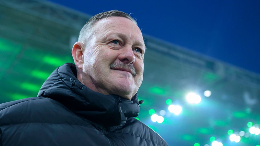 Roland Virkus grinst. Im Hintergrund ist das Dach des Borussia-Parks in grün.