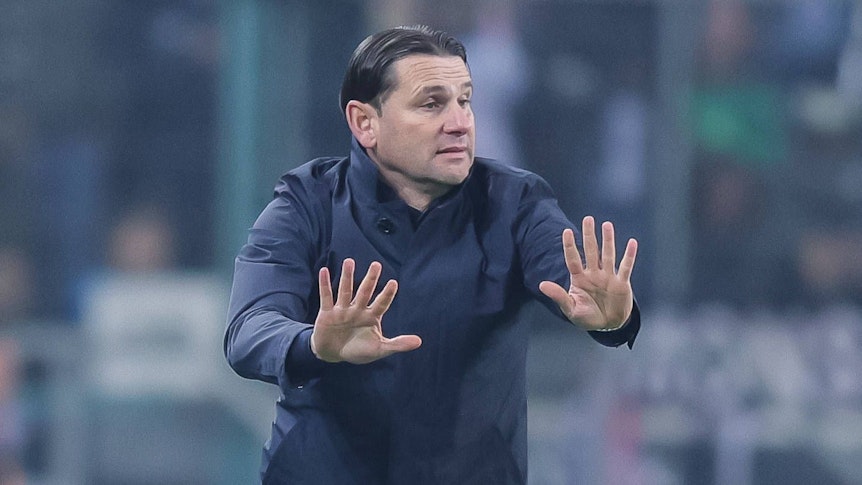 Borussia Mönchengladbachs Trainer Gerardo Seoane steht beim Bundesliga-Spiel gegen Eintracht Frankfurt am Spielfeldrand und mahnt mit beiden Händen zur Ruhe.