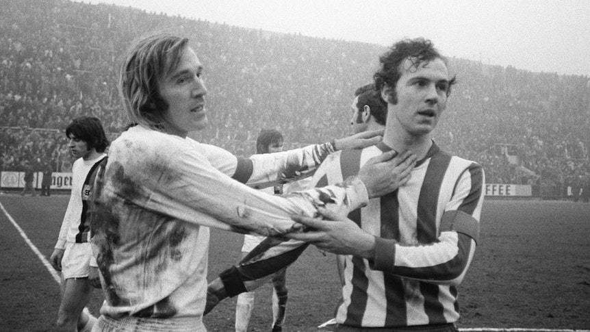 Borussia Mönchengladbachs Günter Netzer und Bayern Münchens Franz Beckenbauer umarmen sich nach dem Bundesliga-Spiel ihrer beiden Vereine.