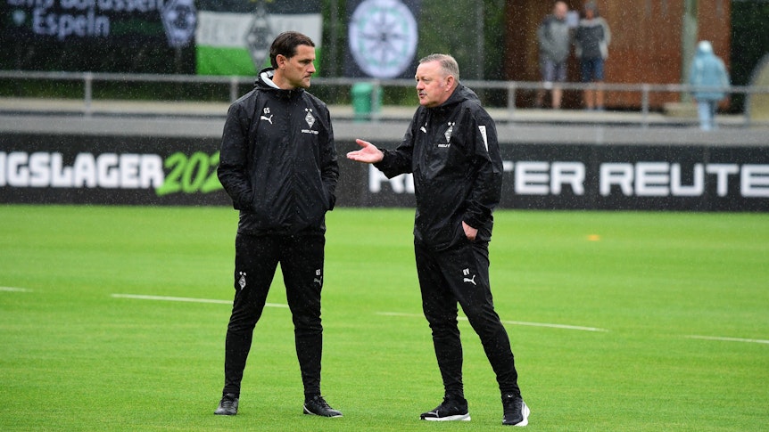 Gerardo Seoane und Roland Virkus unterhalten sich im Regen.