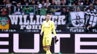 Jonas Omlin zieht sich die Handschuhe auf dem Feld aus.