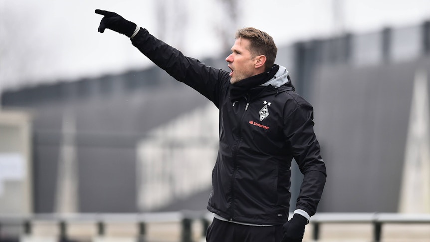 Oliver Kirch hebt den Arm und ruft etwas.