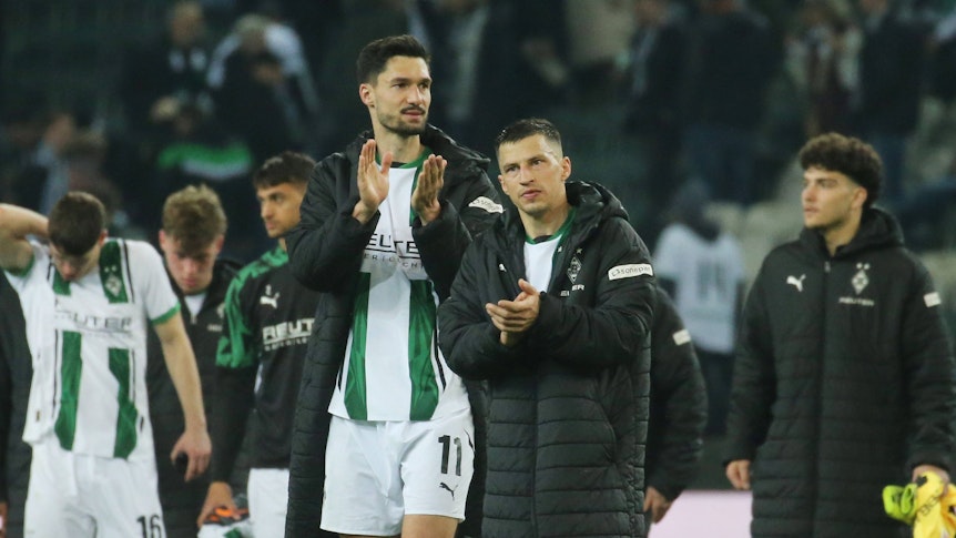 Die Gladbach-Profis Tim Kleindienst und Stefan Lainer laufen nach dem Bundesliga-Heimspiel gegen den 1. FSV Mainz 05 nebeneinander über den Platz und applaudieren den Fans.