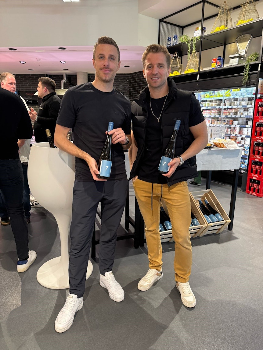 Ex-Gladbach-Profi Patrick Herrmann und Sommelier Ronny Schreiber posieren am Mittwoch (19. März 2025) in Mönchengladbach mit ihrem Wein „Nummer sieben“.