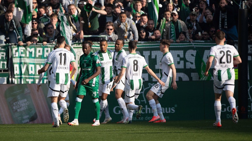 Gladbach-Spieler jubeln gemeinsam.