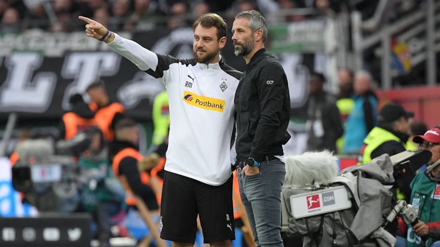René Maric zeigt Gladbach-Trainer Marco Rose etwas an der Seitenlinie.