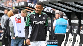Alassane Plea vor der Borussia-Bank in Trainingsklamotte.