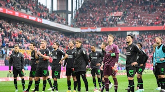 Spieler von Borussia Mönchengladbach vor der Fankurve.