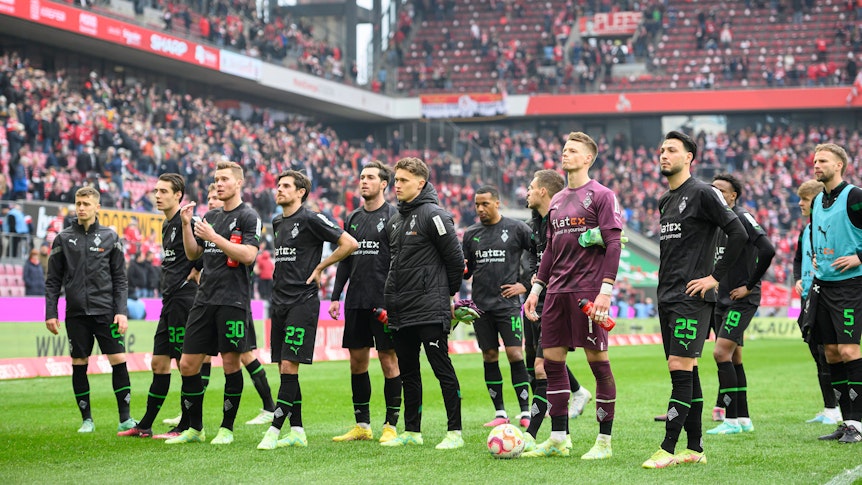 Spieler von Borussia Mönchengladbach vor der Fankurve.