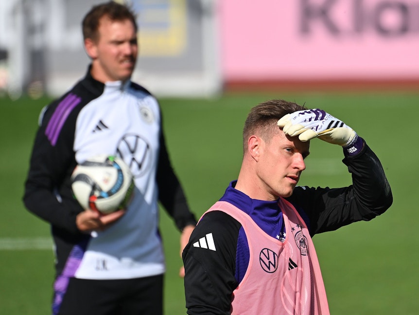 Marc-Andre ter Stegen schützt beim Training seine Augen mit der Hand vor der Sonne, im Hintergrund steht Julian Nagelsmann.