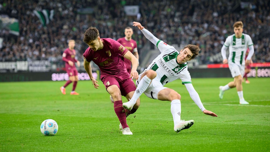 Florian Neuhaus bei einem Zweikampf gegen Augsburgs Mert Kömür.