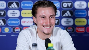 Rocco Reitz strahlt bei einer Pressekonferenz.
