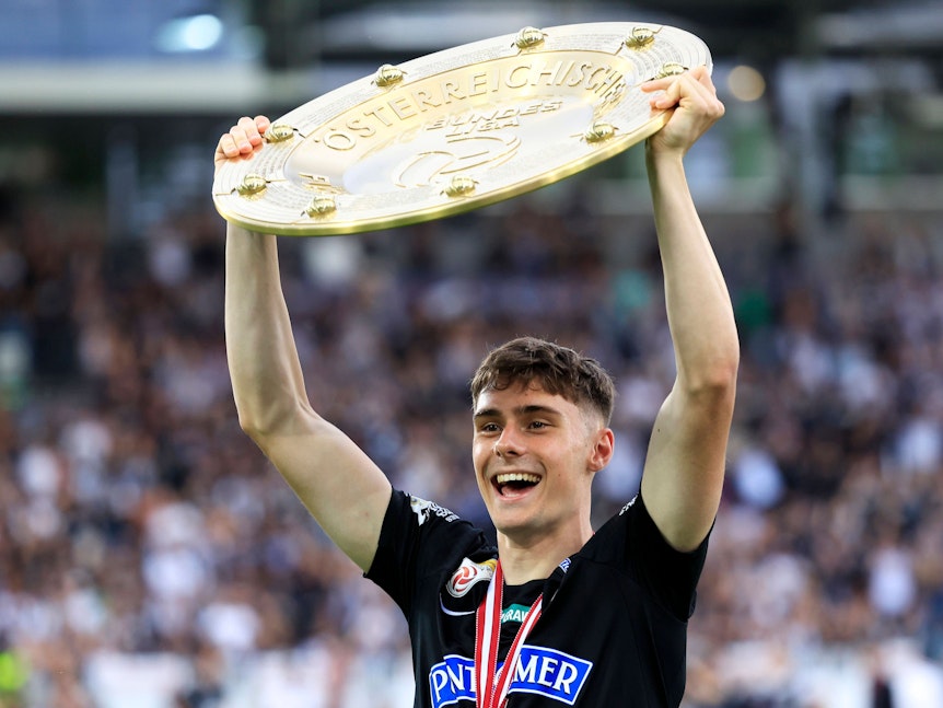 Szymon Wlodarczyk hält die Meisterschale nach oben.