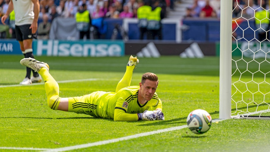 Marc-André ter Stegen liegt auf dem Boden und schaut dem Ball hinterher.