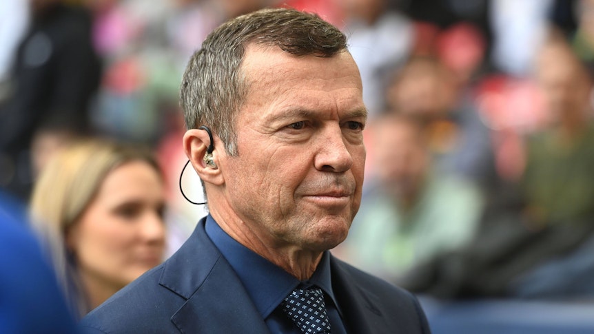 Lothar Matthäus im Anzug an der Seitenlinie.