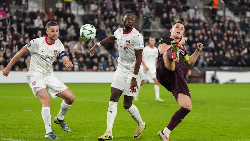 Omar Traoré schaut darauf, wie Lawrence Shankland verzweifelt versucht, den Ball unter Kontrolle zu bringen.
