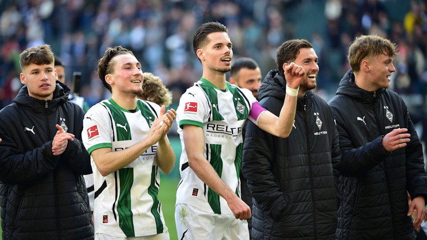 Spieler von Borussia Mönchengladbach feiern mit den Fans.