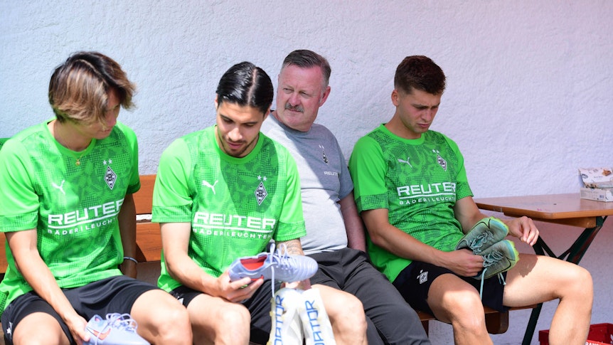 Ko Itakura (l.), Kevin Diks (2.v.l), Roland Virkus und Oscar Fraulo (r.) sitzen auf einer Bank.