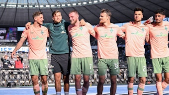 Spieler von Werder Bremen jubeln mit den Fans im Olypiastadion.