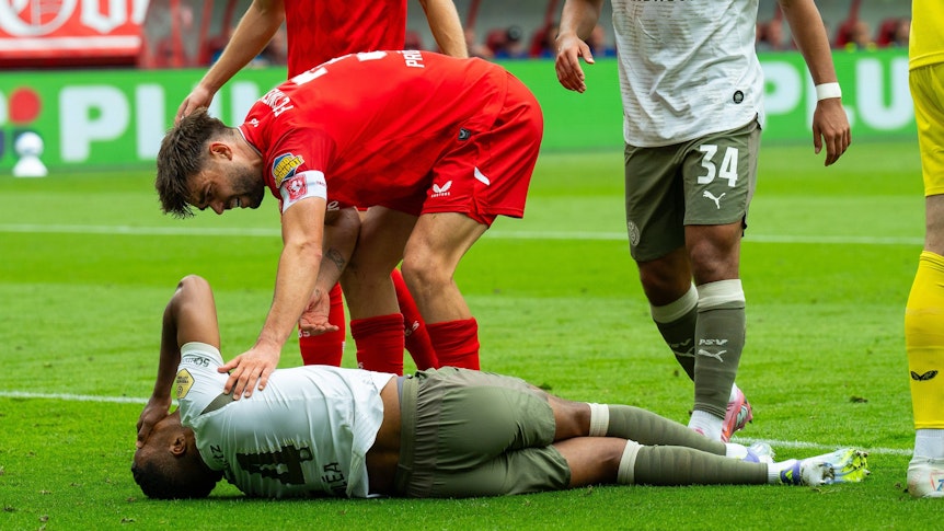 Alassane Plea bleibt bei der Partei gegen den FC Twente am 17. August 2025 unter Schmerzen am Boden liegen.