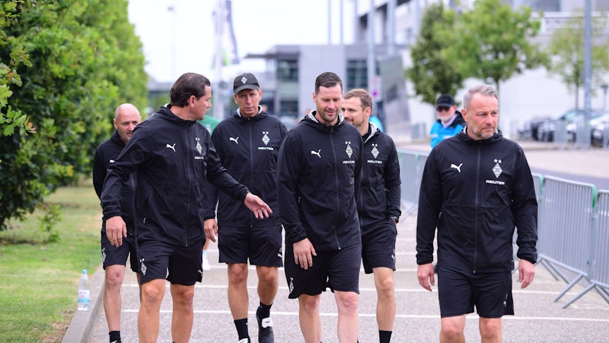 Das Trainerteam von Borussia Mönchengladbach betritt den Platz.