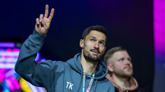 Tim Kleindienst zeigt das Peace-Zeichen zu den Fans in einer Halle.
