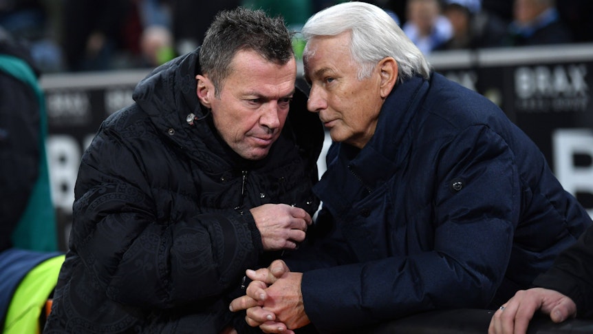 Lothar Matthäus und Rainer Bonhof flüstern miteinander.