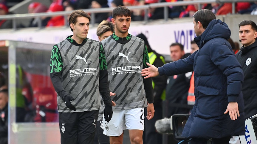 Florian Neuhaus und Fabio Chiarodia kommen vom Aufwärmen zurück zur Bank.