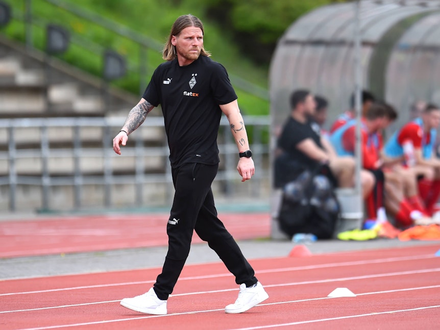 Eugen Polanski geht über die Tartanbahn neben dem Spielfeld.