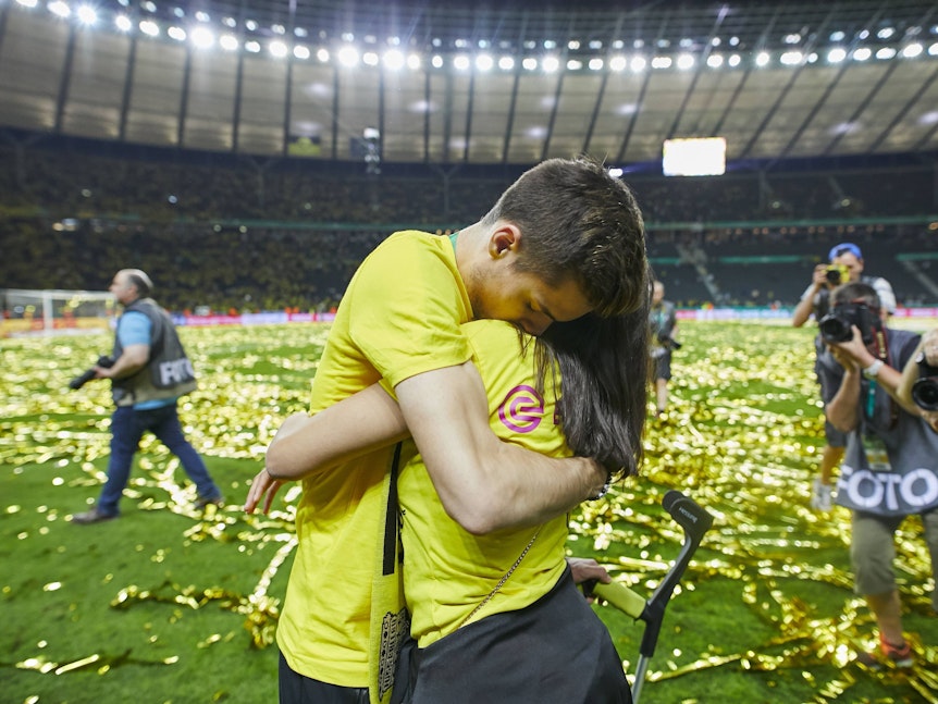 Julian Weigl umarmt Sarah Richmond.