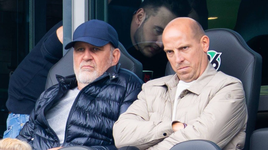 Jörg Schmadtke und Jan Schlaudraff schauen etwas finster auf der Tribüne.