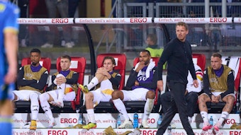 Rocco Reitz und mehrere Nationalspieler sitzen hinter Bundestrainer Julian Nagelsmann auf der Bank.