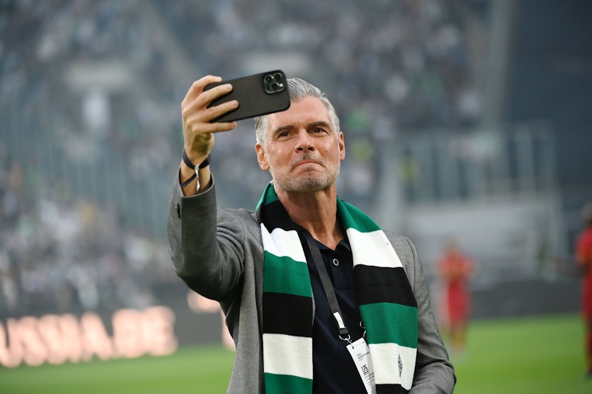 Karlheinz Pflipsen macht ein Selfie im Borussia-Park, trägt dabei einen Gladbach-Schal.