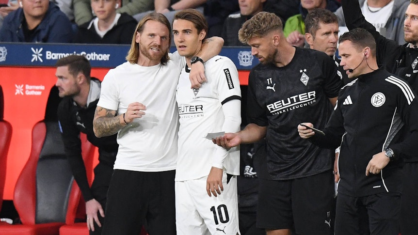 Gladbach-Trainer Eugen Polanski nimmt Florian Neuhaus in den Arm und gibt ihm Anweisungen vor der Einwechslung.