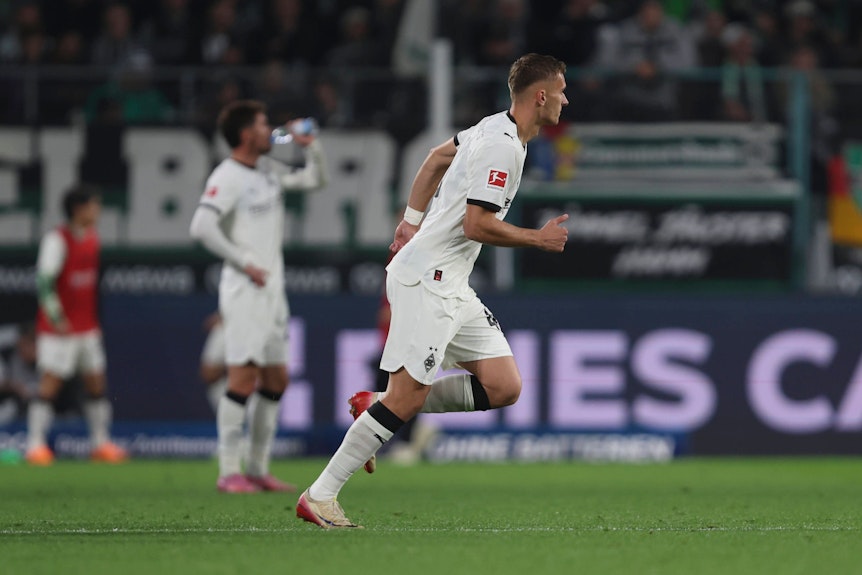 Jan Urbich läuft in seinem weißen Trikot auf dem Fußballfeld.