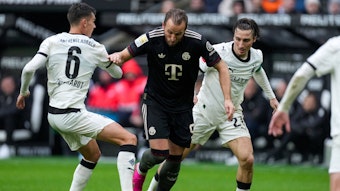 Harry Kane dribbelt gegen Gladbach-Spieler.