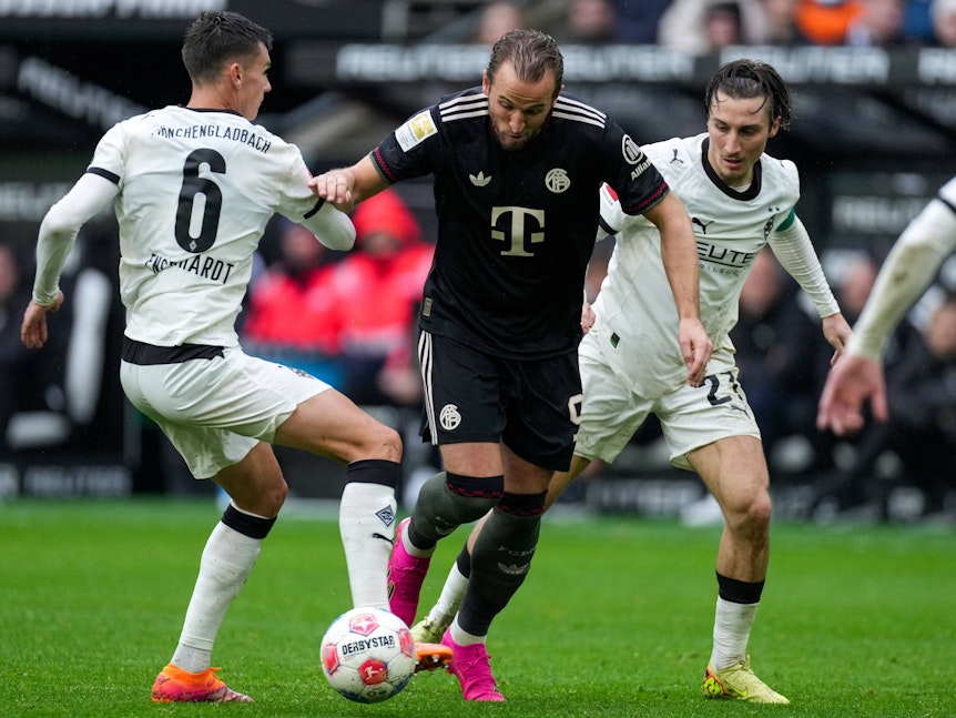 Harry Kane dribbelt gegen Gladbach-Spieler.