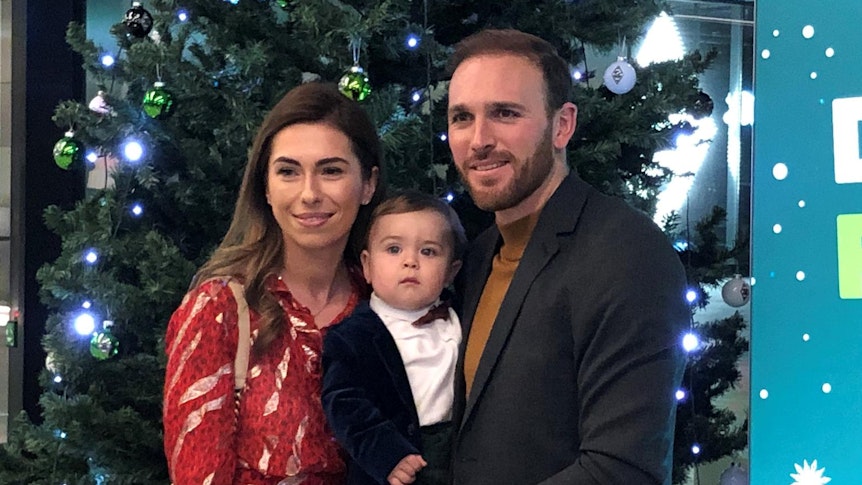 Gladbach-Torhüter Tobias Sippel (r.) mit Frau Sandra (l.) und Sohn Lenn bei der Borussia-Weihnachtsfeier 2019 im Borussia-Park. Sippel lächelt.